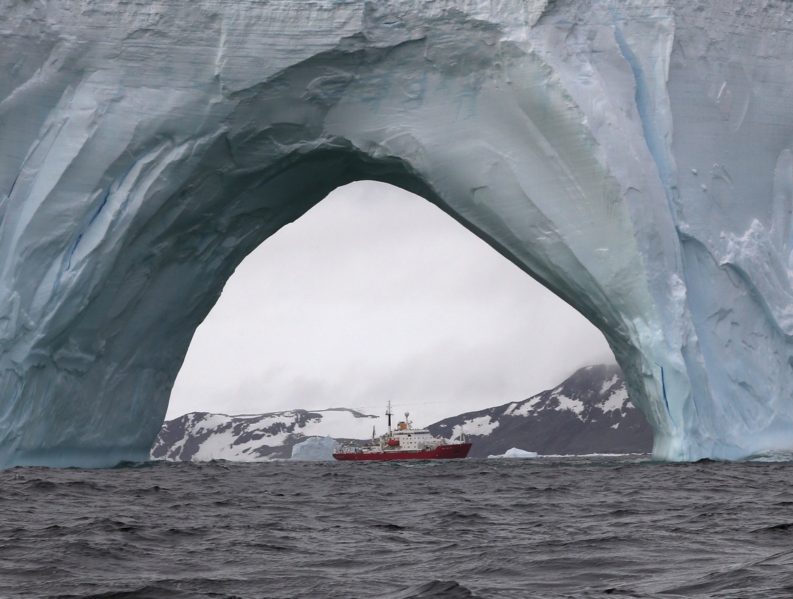 RRS James Clark Ross through an iceberg arch